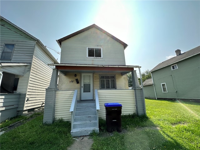 rear view of property featuring a lawn