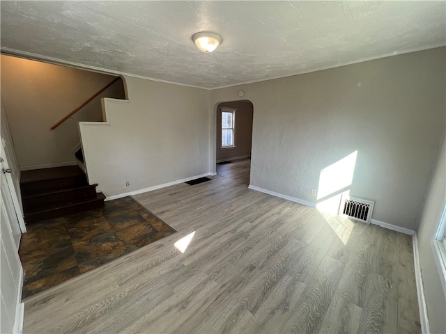 unfurnished living room featuring a textured ceiling and hardwood / wood-style floors