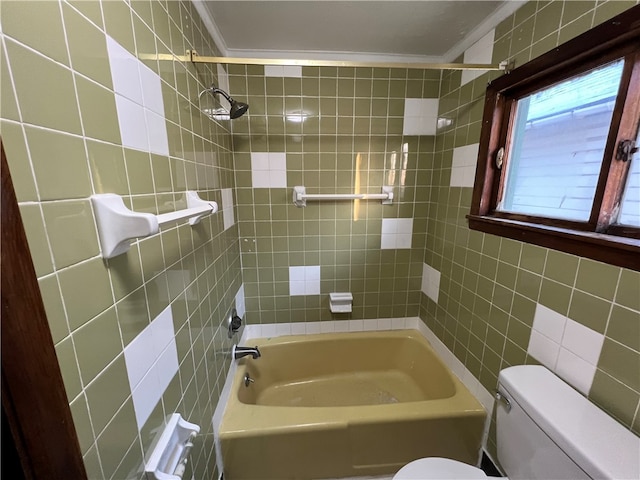 bathroom with tile walls, ornamental molding, tiled shower / bath combo, and toilet