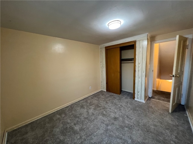 unfurnished bedroom featuring a closet and dark carpet