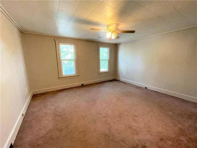 empty room with ceiling fan, ornamental molding, and carpet floors