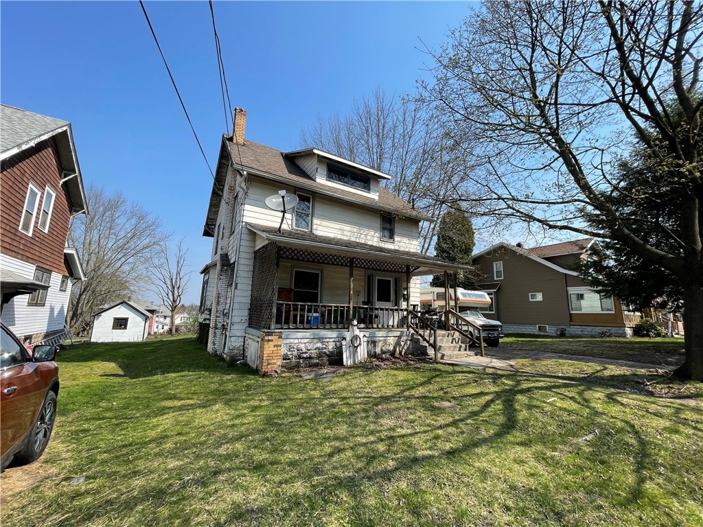 rear view of property with a lawn