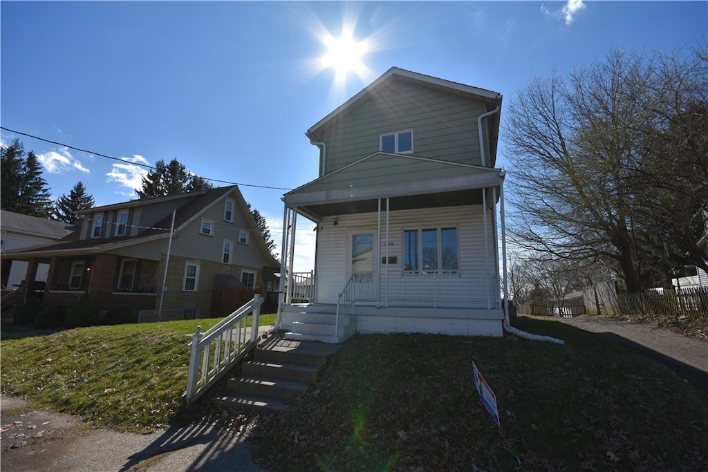 view of front of house with a porch and a front yard