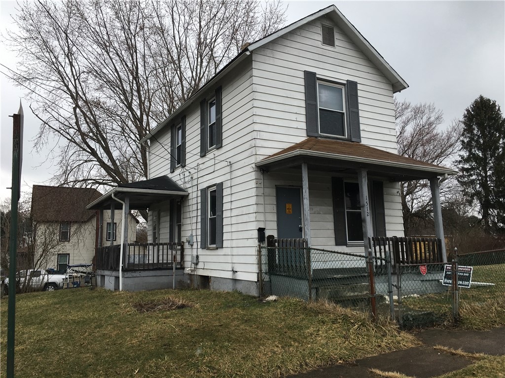 view of front of home with a porch and a front lawn