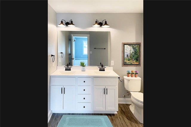 bathroom with hardwood / wood-style floors, vanity, and toilet