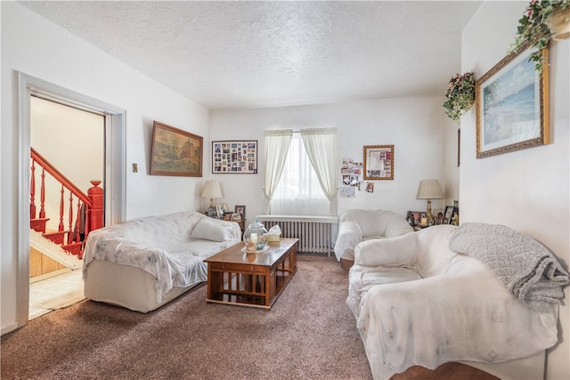 carpeted living room featuring radiator heating unit and a textured ceiling