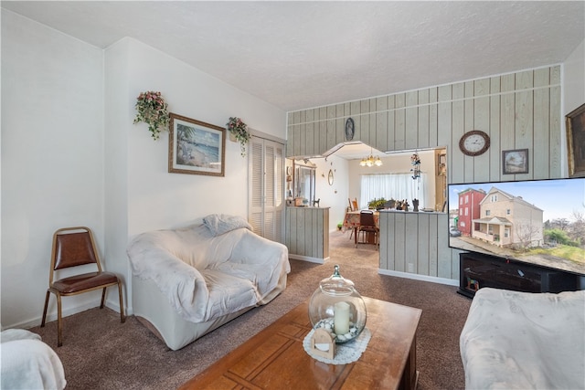 carpeted living room featuring an inviting chandelier