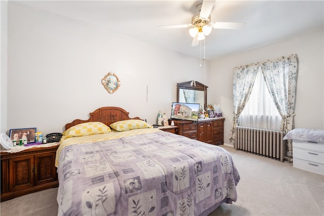 bedroom featuring light carpet, ceiling fan, and radiator