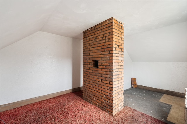 bonus room featuring brick wall and vaulted ceiling