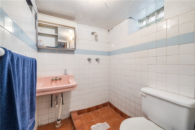 bathroom with tile walls, toilet, and tile floors