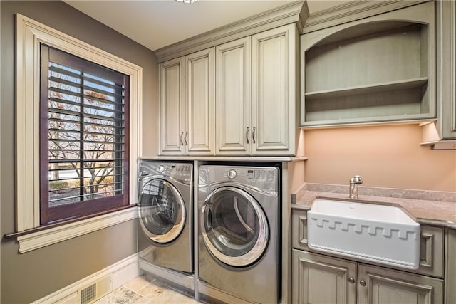 laundry area featuring washing machine and clothes dryer, sink, cabinets, and light tile patterned floors