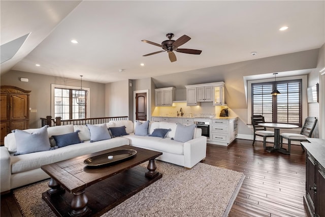 living room with dark hardwood / wood-style flooring, sink, and ceiling fan