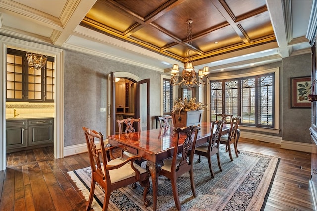 dining space with beam ceiling, crown molding, a chandelier, dark hardwood / wood-style flooring, and coffered ceiling