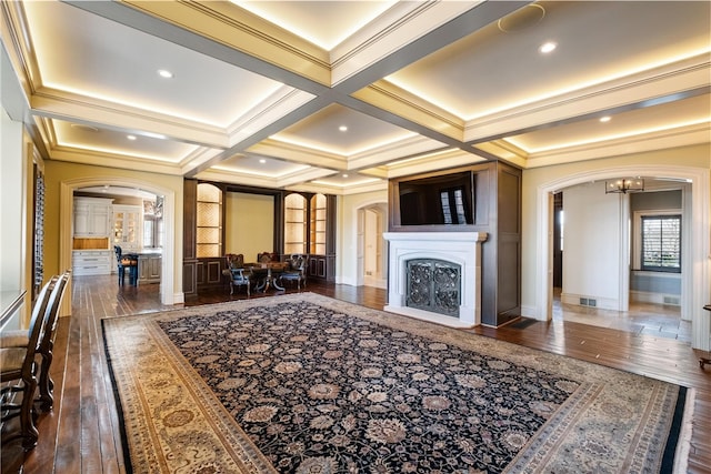 living room with dark hardwood / wood-style flooring, coffered ceiling, and ornamental molding