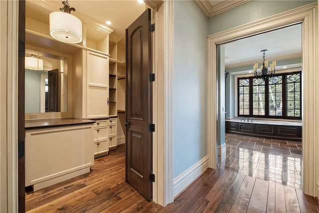 hall with crown molding, dark hardwood / wood-style floors, and a chandelier