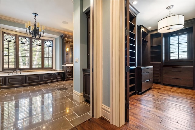 interior space featuring ornamental molding, a notable chandelier, and dark hardwood / wood-style floors