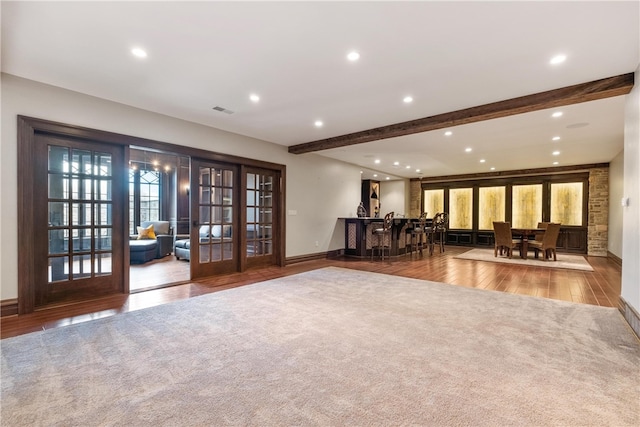 interior space with french doors, wood-type flooring, and beam ceiling