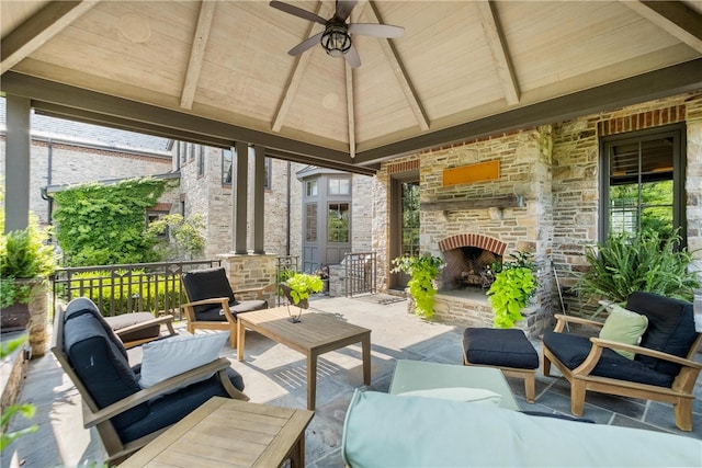 view of patio / terrace with an outdoor living space with a fireplace and ceiling fan