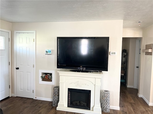 living room featuring a textured ceiling and dark hardwood / wood-style floors