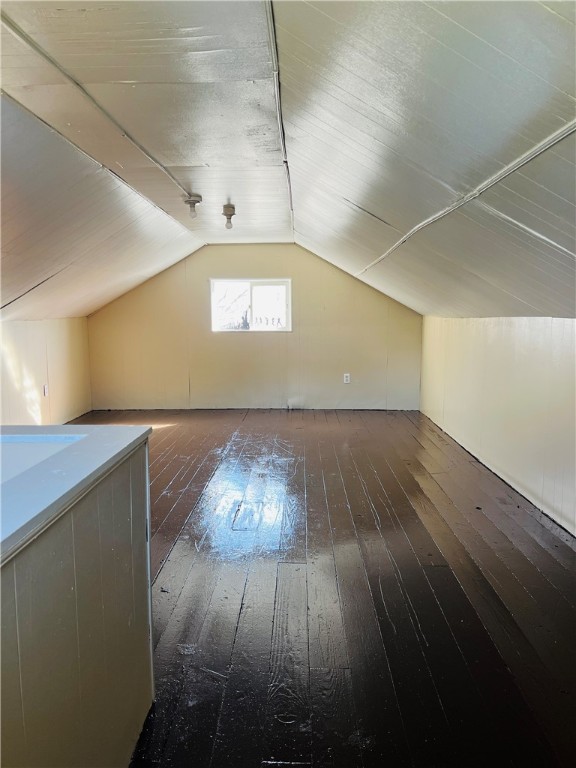 bonus room featuring lofted ceiling and dark hardwood / wood-style flooring