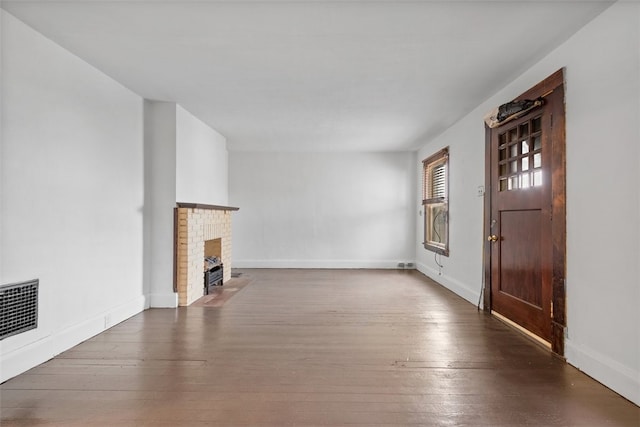 unfurnished living room with a fireplace and dark wood-type flooring