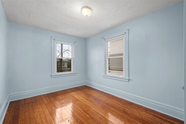 empty room with dark hardwood / wood-style floors and a textured ceiling