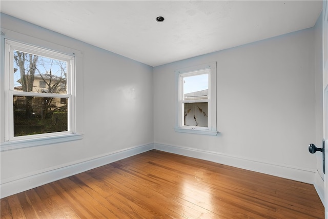 empty room featuring dark hardwood / wood-style flooring and a healthy amount of sunlight