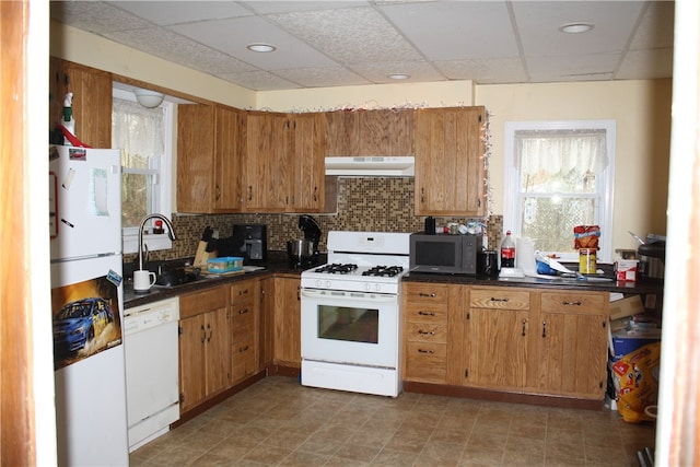 kitchen with white appliances, sink, light tile floors, a paneled ceiling, and backsplash