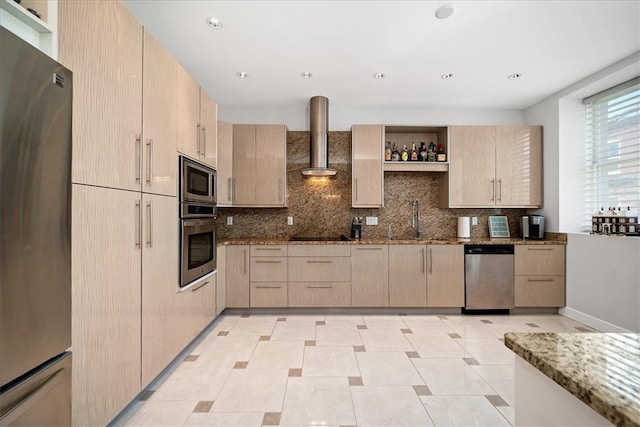 kitchen featuring wall chimney range hood, dark stone countertops, and stainless steel appliances