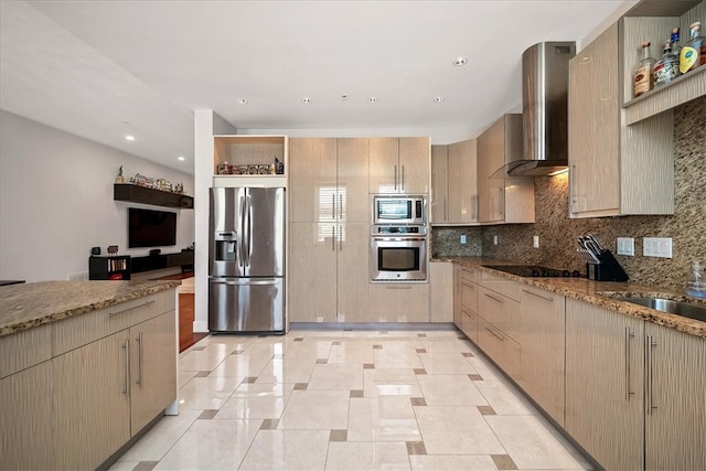 kitchen with appliances with stainless steel finishes, dark stone counters, backsplash, and wall chimney range hood