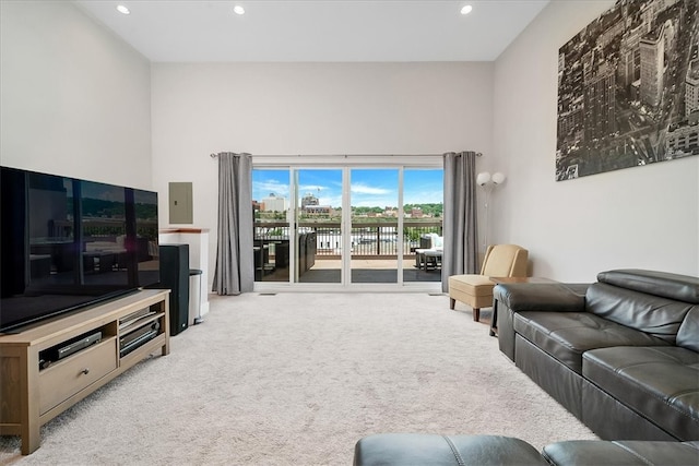 carpeted living room featuring a towering ceiling