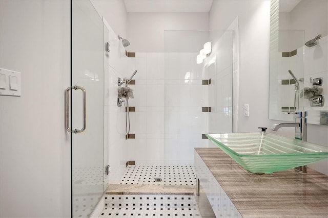 bathroom with a shower with shower door and sink