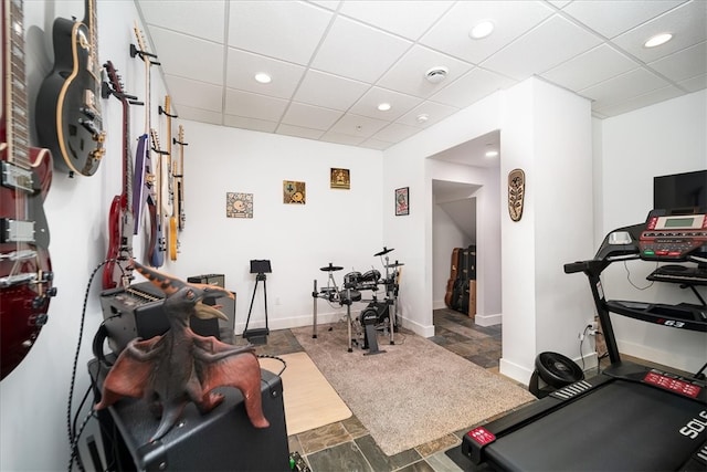 exercise room with dark tile flooring and a drop ceiling