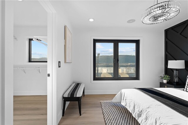 bedroom with light hardwood / wood-style flooring and a notable chandelier