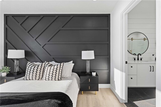 bedroom featuring light wood-type flooring and sink