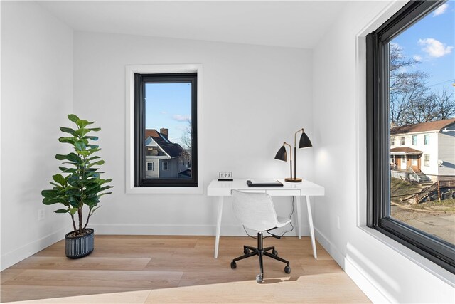 home office featuring lofted ceiling and light hardwood / wood-style flooring