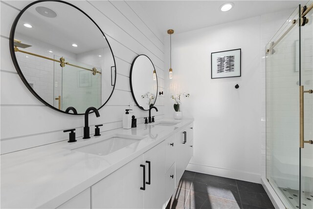 bathroom featuring tile flooring, vanity with extensive cabinet space, dual sinks, and walk in shower