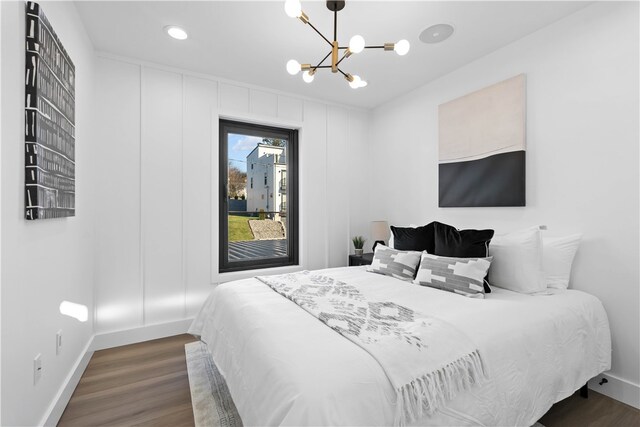 bedroom featuring an inviting chandelier and dark hardwood / wood-style flooring