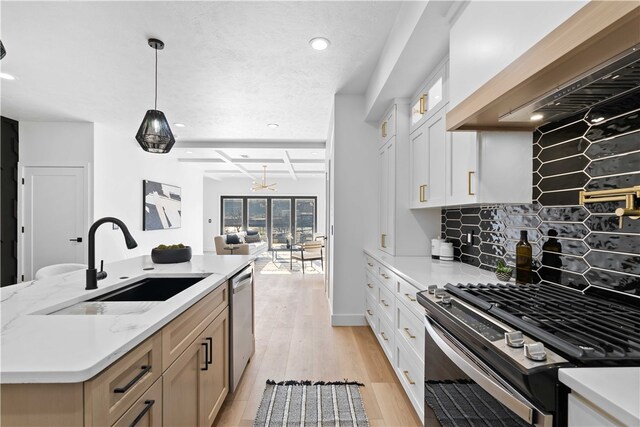 kitchen featuring hanging light fixtures, tasteful backsplash, stainless steel appliances, custom exhaust hood, and white cabinetry