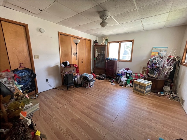 misc room with a drop ceiling and light hardwood / wood-style flooring