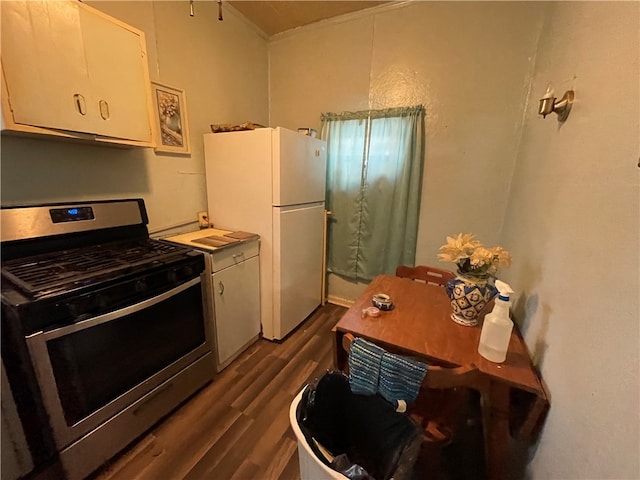 kitchen with white cabinets, white fridge, dark hardwood / wood-style floors, and stainless steel gas range oven