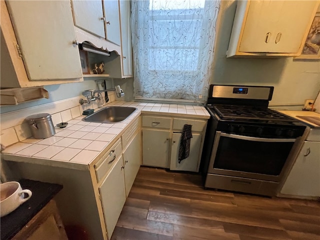 kitchen featuring tile countertops, stainless steel range with gas stovetop, sink, and dark hardwood / wood-style floors