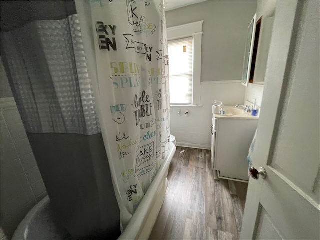 bathroom featuring vanity, shower / tub combo with curtain, wood-type flooring, and tile walls