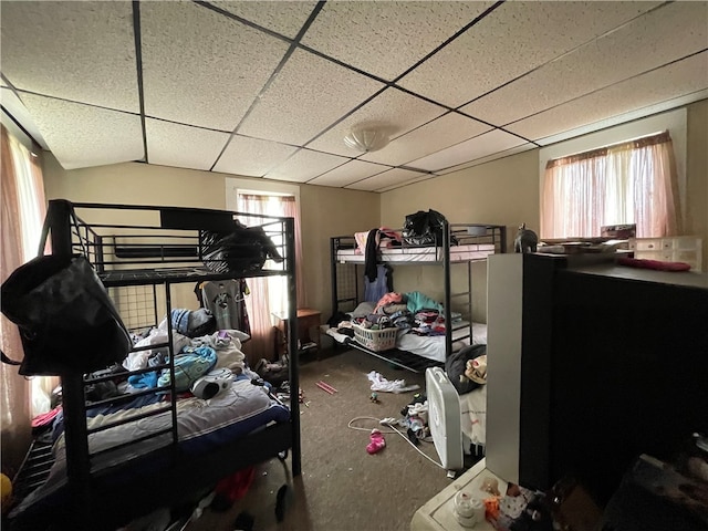 carpeted bedroom with a drop ceiling