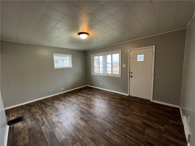 foyer entrance with ornamental molding and dark hardwood / wood-style flooring