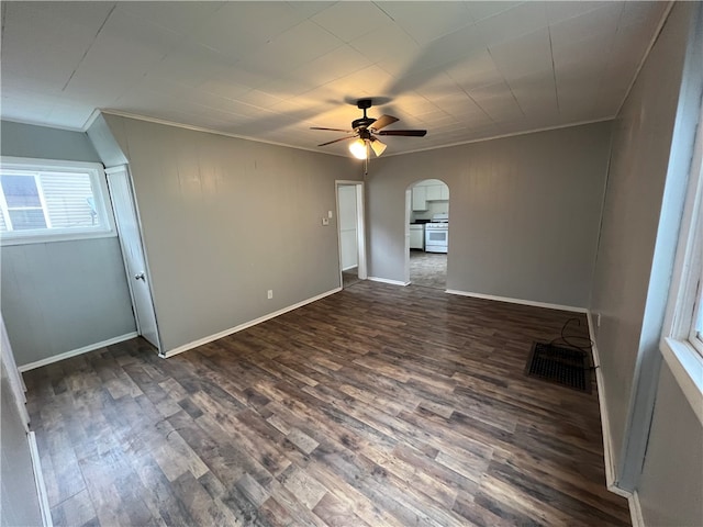 empty room featuring crown molding, dark hardwood / wood-style floors, and ceiling fan