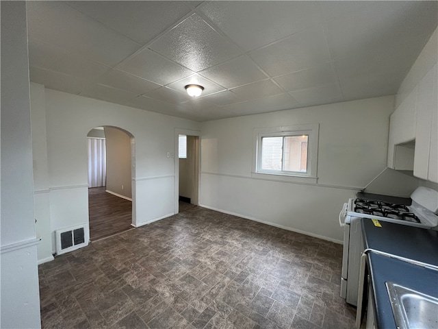 interior space featuring white cabinetry, gas range gas stove, and sink