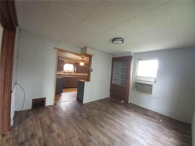 spare room featuring cooling unit, dark hardwood / wood-style floors, and ceiling fan