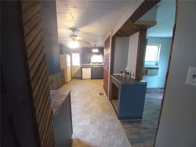 kitchen featuring white appliances, ceiling fan, and a wealth of natural light