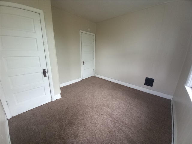 empty room featuring dark carpet